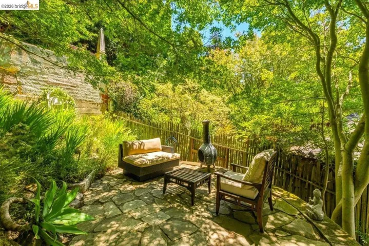Flagstone patio surrounded by lush greenery and mature trees
