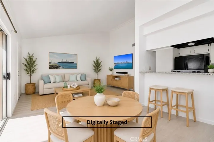 Eating ell opens to balcony views and living room. Digitally staged.