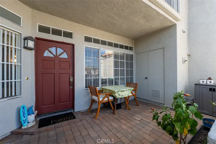 Outside porch area with stackable washer/dryer combo inside side door