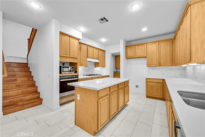 Kitchen with stairway upstairs.