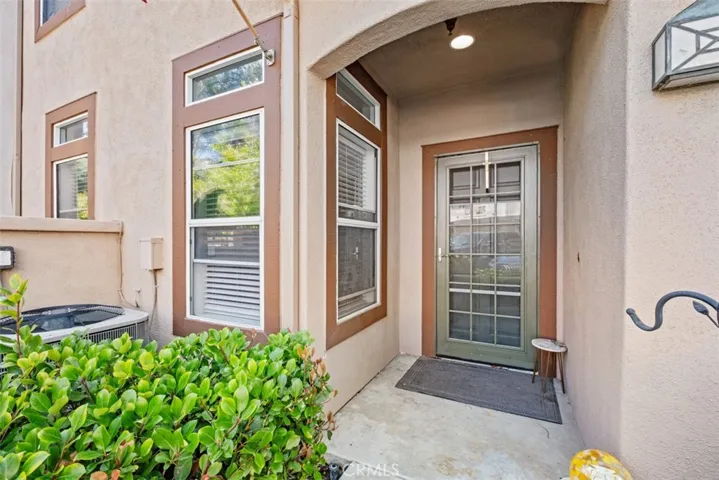 Covered front porch with an inviting entry door and attractive architectural details, offering a sheltered and welcoming arrival experience.