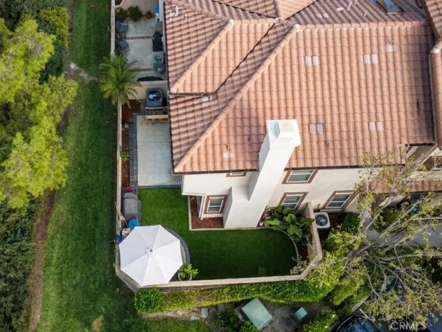 Aerial perspective highlighting the home's roofline, outdoor areas, and position within the surrounding community.