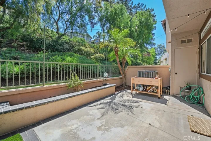 Expansive patio area with peaceful tree-lined views, offering plenty of room for outdoor seating and entertaining.