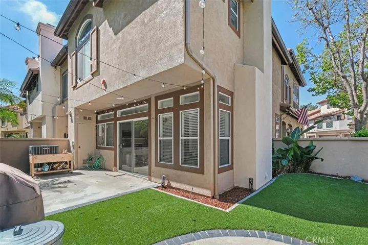 Private extremely rare expanded wrap around backyard patio with low-maintenance brand new turf, and direct access to the home, offering an inviting space for outdoor relaxation.