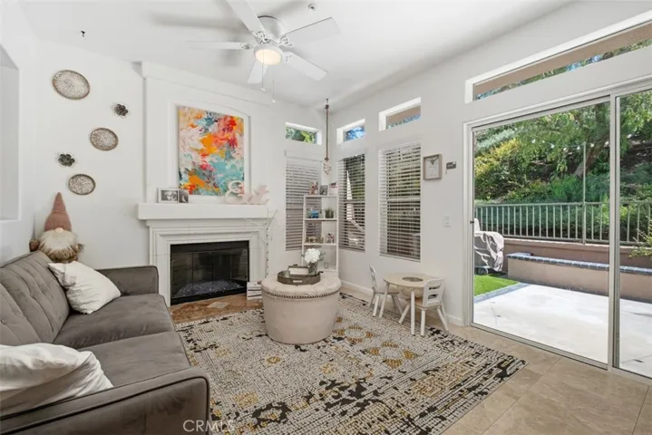 Comfortable family room featuring large windows and sliding glass doors that bring in abundant natural light and backyard views.