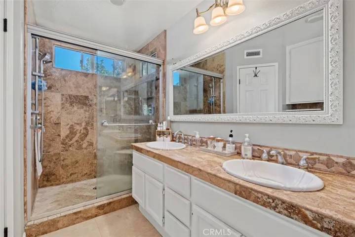 Well-appointed primary bathroom with dual sinks, generous counter space, and a large walk-in shower for everyday comfort and convenience.