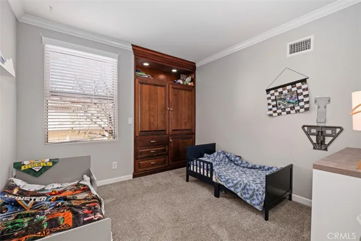 Secondary bedroom with neutral tones, natural light, and flexible space for guests, family, or a home office.