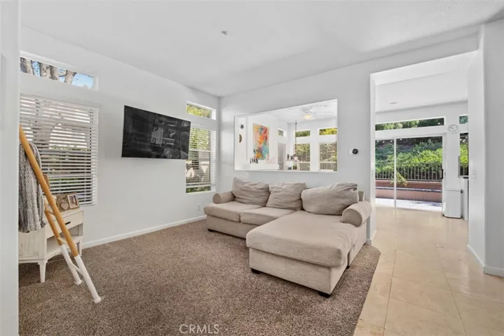 Spacious living room filled with natural light, featuring comfortable gathering areas and views into the surrounding living spaces.