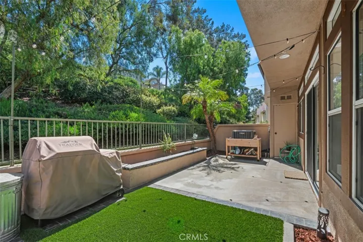 Covered patio overlooking the landscaped yard, creating a comfortable setting for outdoor dining, morning coffee, or evening gatherings.