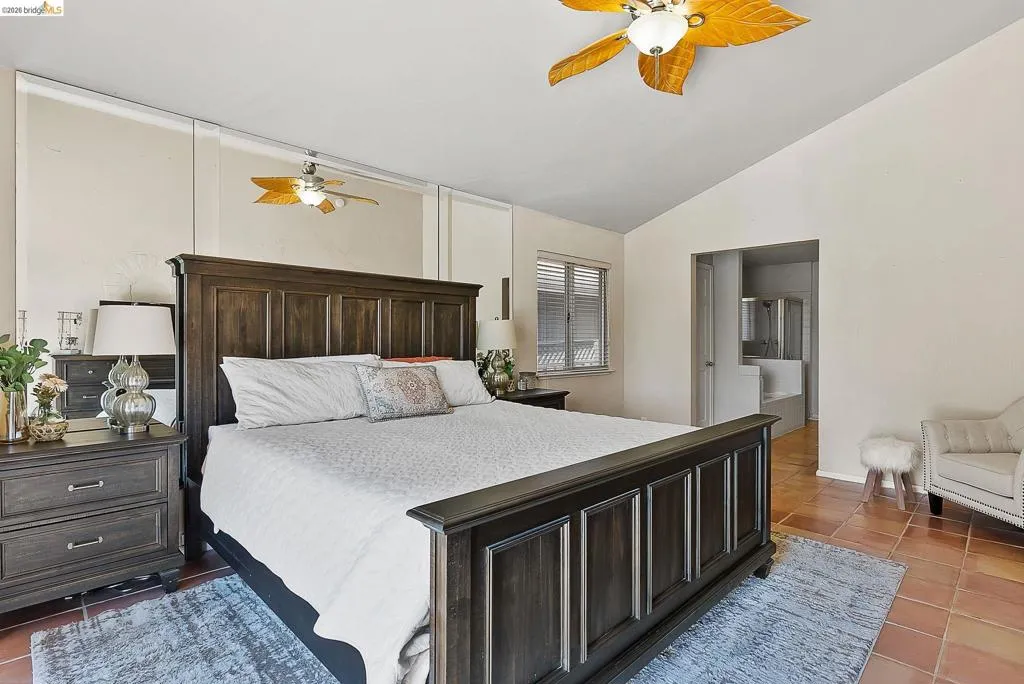 Tiled bedroom with vaulted ceiling and ceiling fan