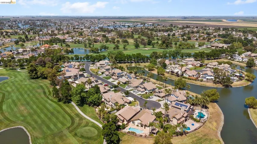 Aerial view of property's location with nearby suburban area, a large body of water, and a golf club