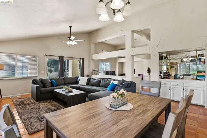 Dining room with a chandelier, a ceiling fan, and high vaulted ceiling