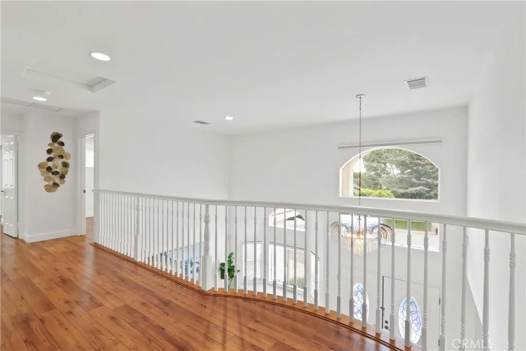 Upstairs hallway overlooking the formal living room and foyer with views of city lights and mountains