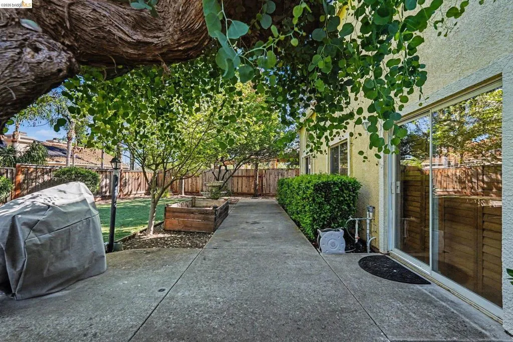 Concrete patio with mature landscaping and privacy fencing