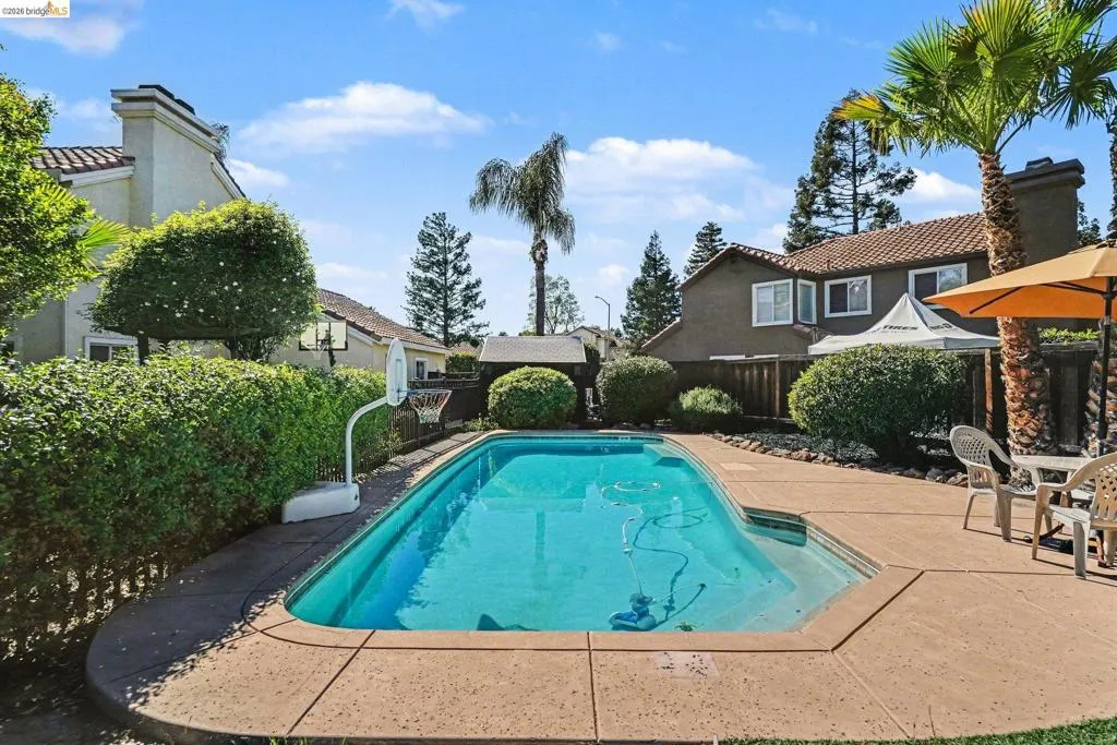 Inviting in-ground swimming pool surrounded by concrete decking