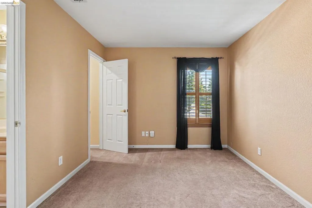 Interior room featuring neutral-toned walls and plush carpet flooring