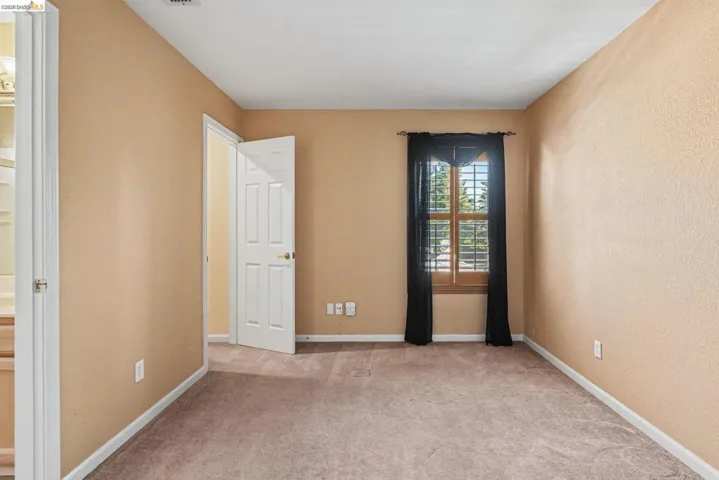 Interior room featuring neutral-toned walls and plush carpet flooring