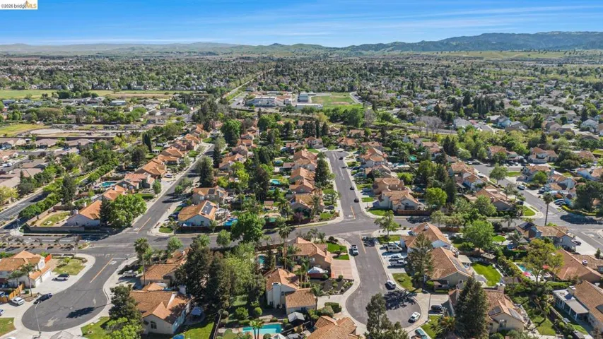 Residential neighborhood with mature trees, paved streets, and a mix of single-story and two-story homes