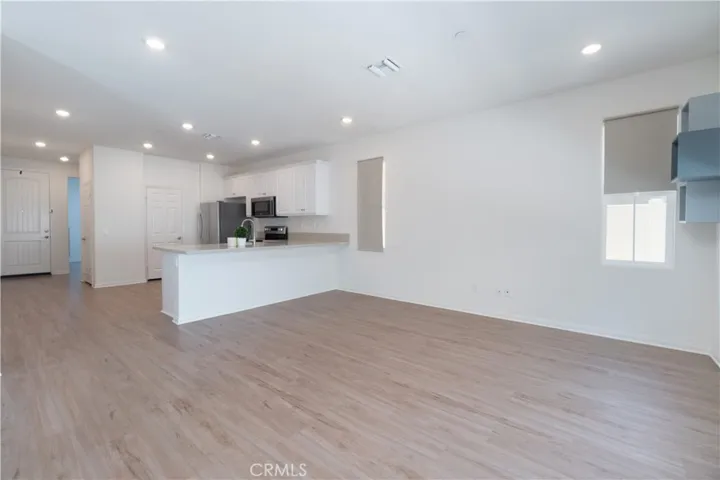 The kitchen seamlessly opens to the light-filled living area perfect for large furniture and your media center