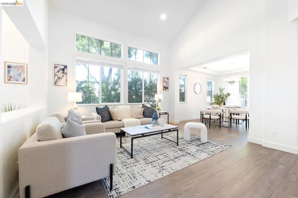 Vaulted ceilings and wood-finish flooring define this expansive living area