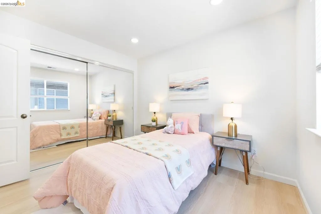 Recessed lighting illuminating light-toned wood-finish flooring