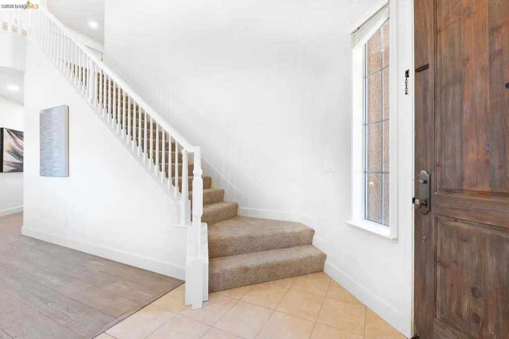 Entryway featuring a wood-finish front door with an adjacent sidelight window
