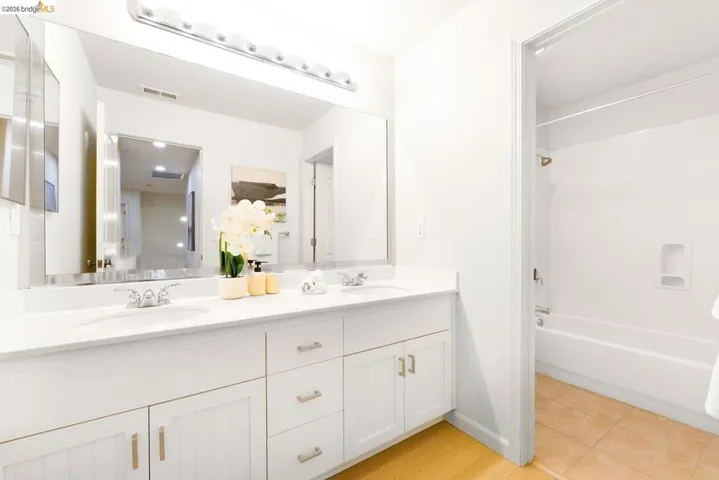 Dual sink vanity with white cabinetry and chrome hardware