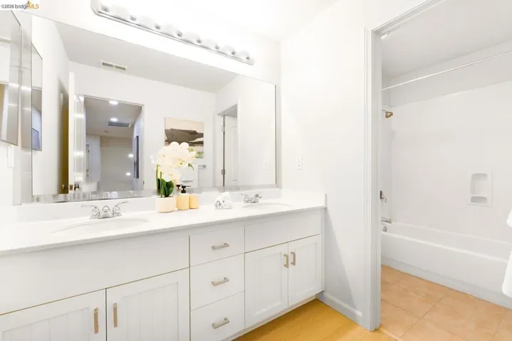 Dual sink vanity with white cabinetry and chrome hardware