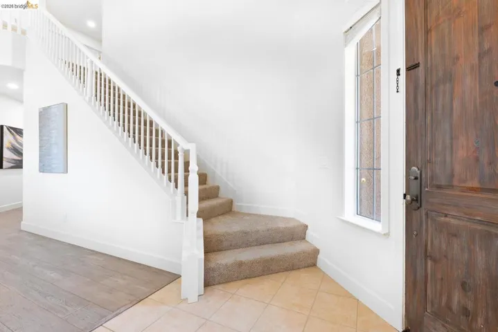 Entryway featuring a wood-finish front door with an adjacent sidelight window