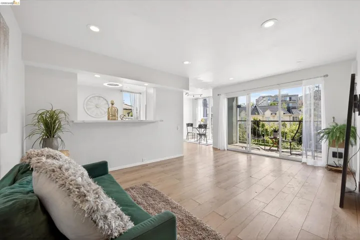 Living area with light wood-finish flooring and recessed lighting