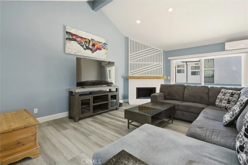 Living Room centered around decorative gas fireplace with a minisplit AC unit