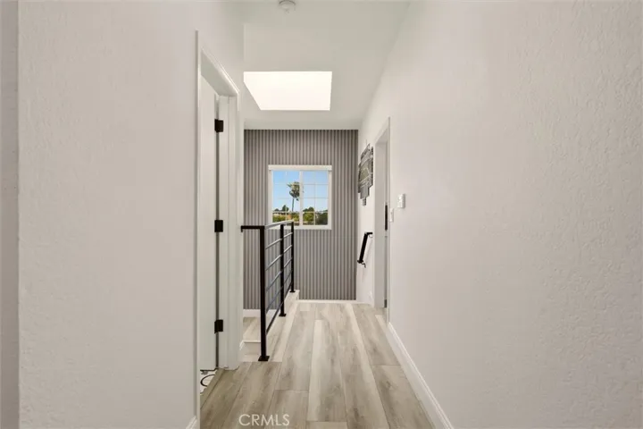 Upstairs hallway leading to Primary Bedroom, laundy room, and half bath to the west and the living room to the south, and the kitchen to the East
