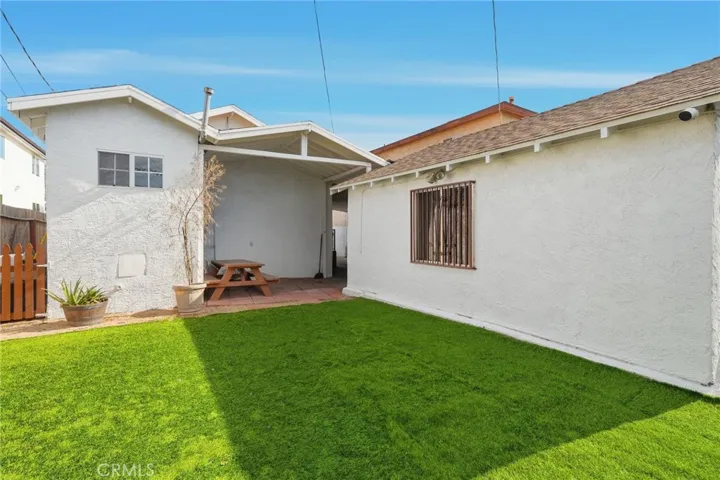A resort-style backyard with its manicured lawn and mature trees and flowers perfect for children fun and entertainment.