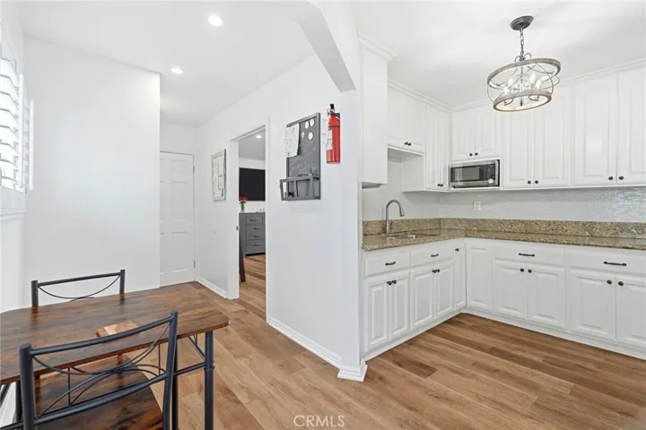 A modern kitchen featuring granite countertops, custom white cabinetry, and premium stainless-steel appliances