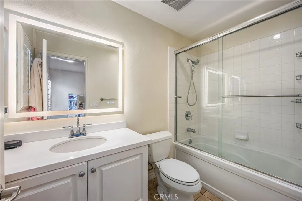 Full bathroom with updated vanity, framed mirror, and tub/shower combination
