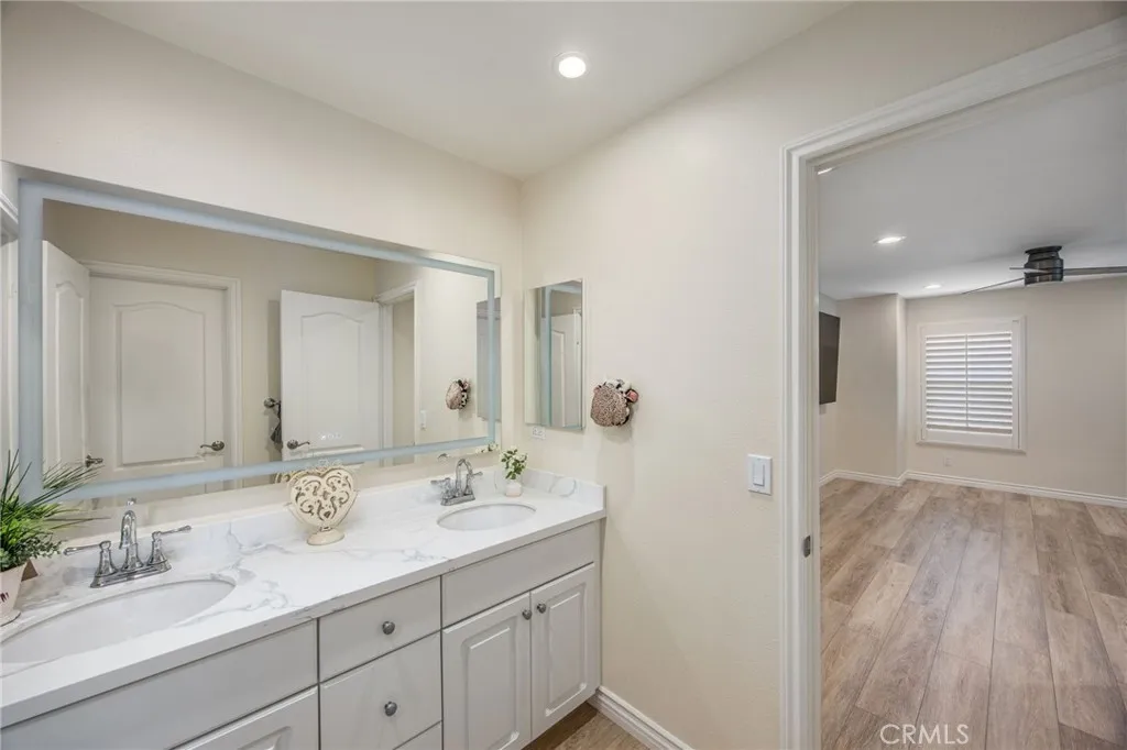 Dual-sink bathroom with quartz countertops and convenient access from adjoining bedrooms