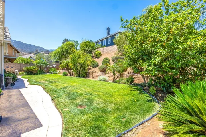 Private backyard featuring mature trees, established landscaping, and generous open lawn space