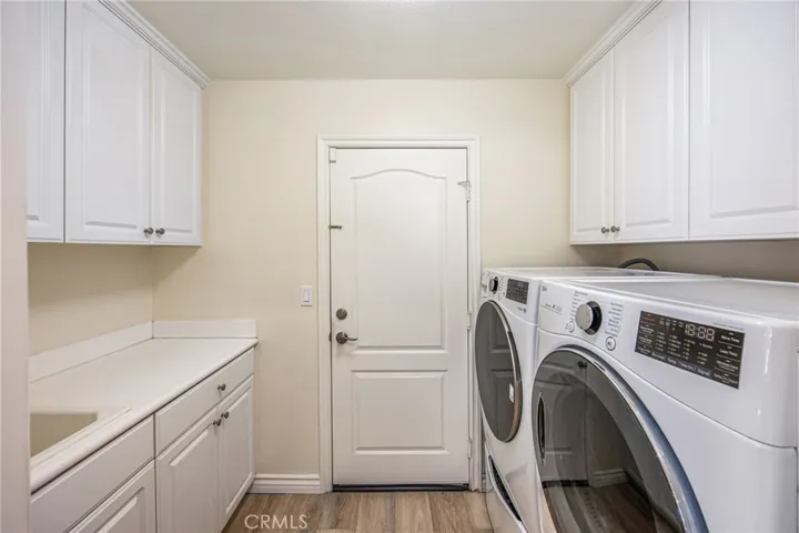Laundry room with utility sink, counter space, and built-in storage