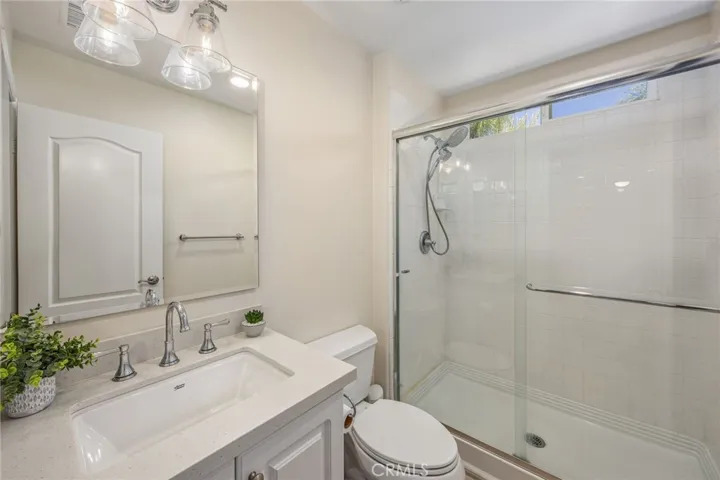 Convenient full bathroom with contemporary finishes and a walk-in shower