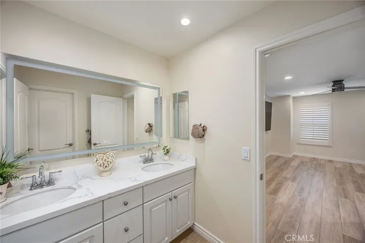 Dual-sink bathroom with quartz countertops and convenient access from adjoining bedrooms