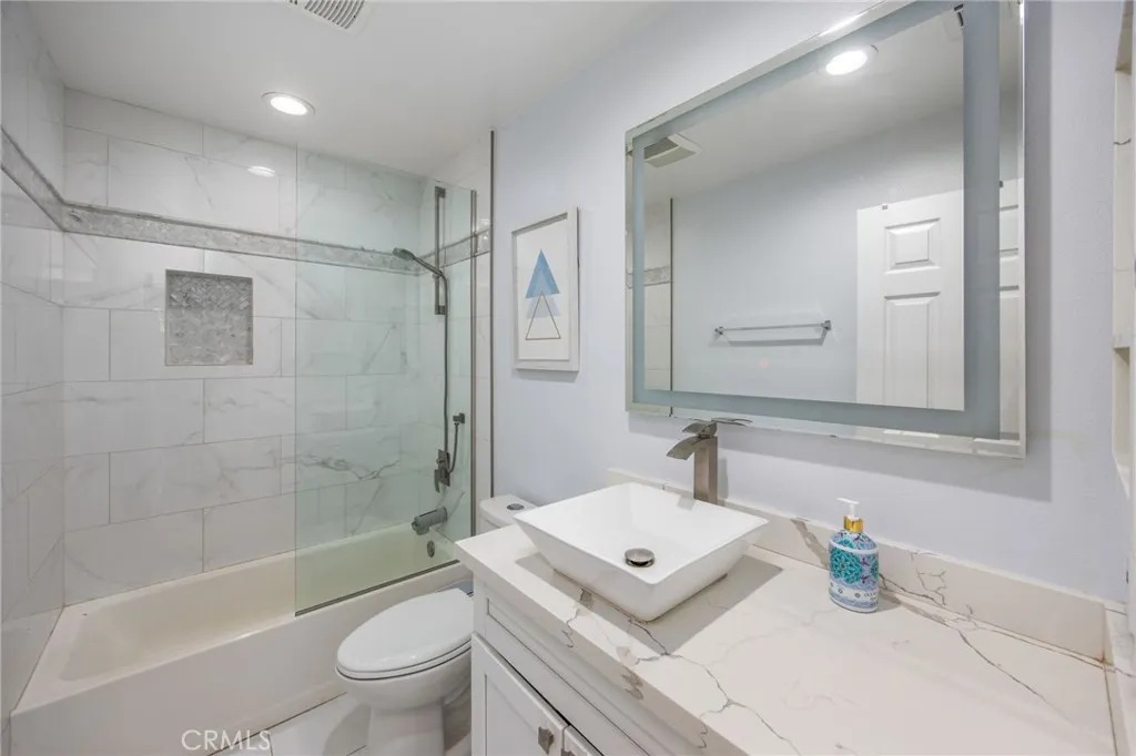 Updated bathroom with a spacious vanity and tiled tub-shower combination