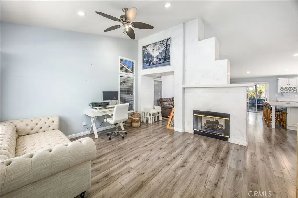 Open-concept living area highlighted by soaring ceilings and a central fireplace