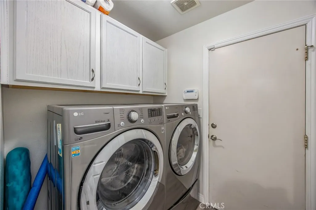 Laundry room with overhead cabinetry for convenient storage