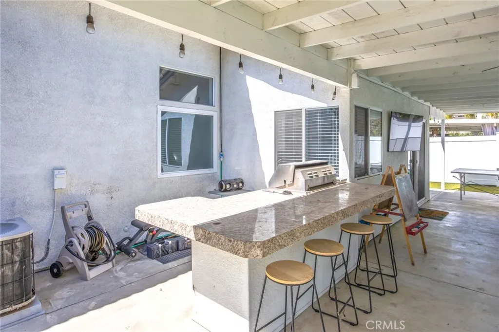 Built-in barbecue and bar seating under the covered patio