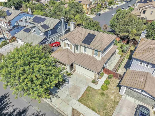 Two-story residence featuring a tile roof, solar panels, and a stone facade accent