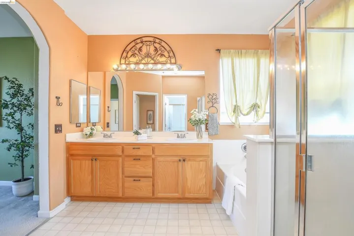 Double vanity with light wood cabinetry and a white countertop