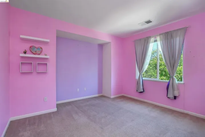 Carpeted room featuring a double window, built-in wall niche, and two floating wall shelves