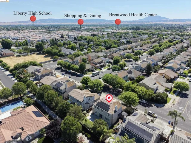 Aerial view of a residential neighborhood with distant hills and a clear sky