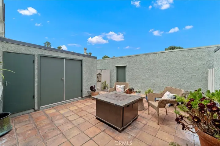 Pater enclosed patio with laundry closet, storage closet, stucco walls, and door to two-car garage