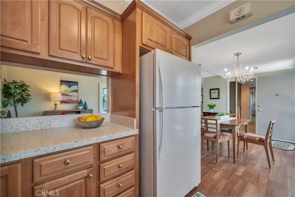 Pass through window from kitchen to living room. Vinyl flooring in kitchen and dining area